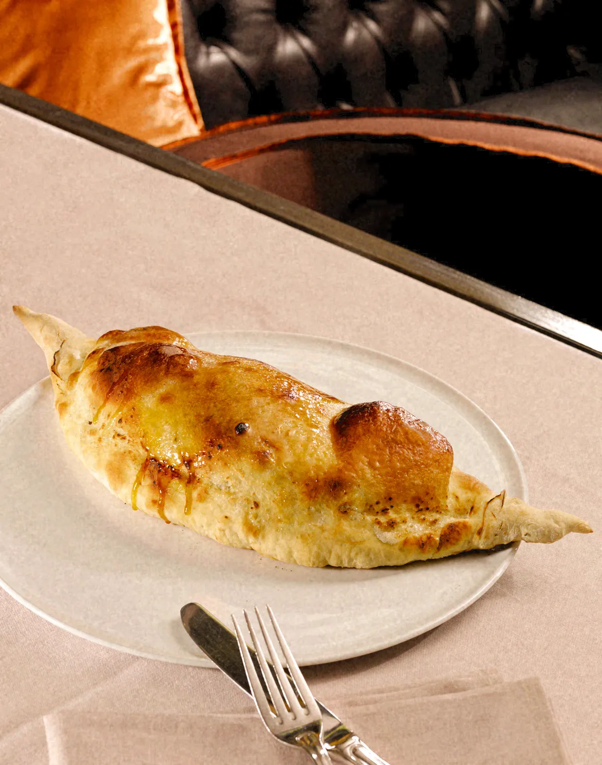 A golden Calzone Dolce served on a white plate at Park Hotel.